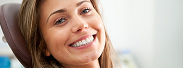 Young woman with healthy smile in dental chair