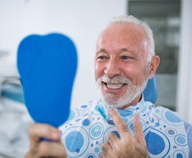 senior man seeing his new smile with dental implants in Washington, DC  