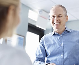 Smiling man checking in at reception desk