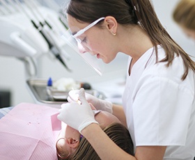 Dental assistant treating patient