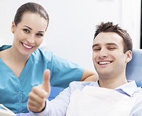 Man in dental chair giving thumbs up