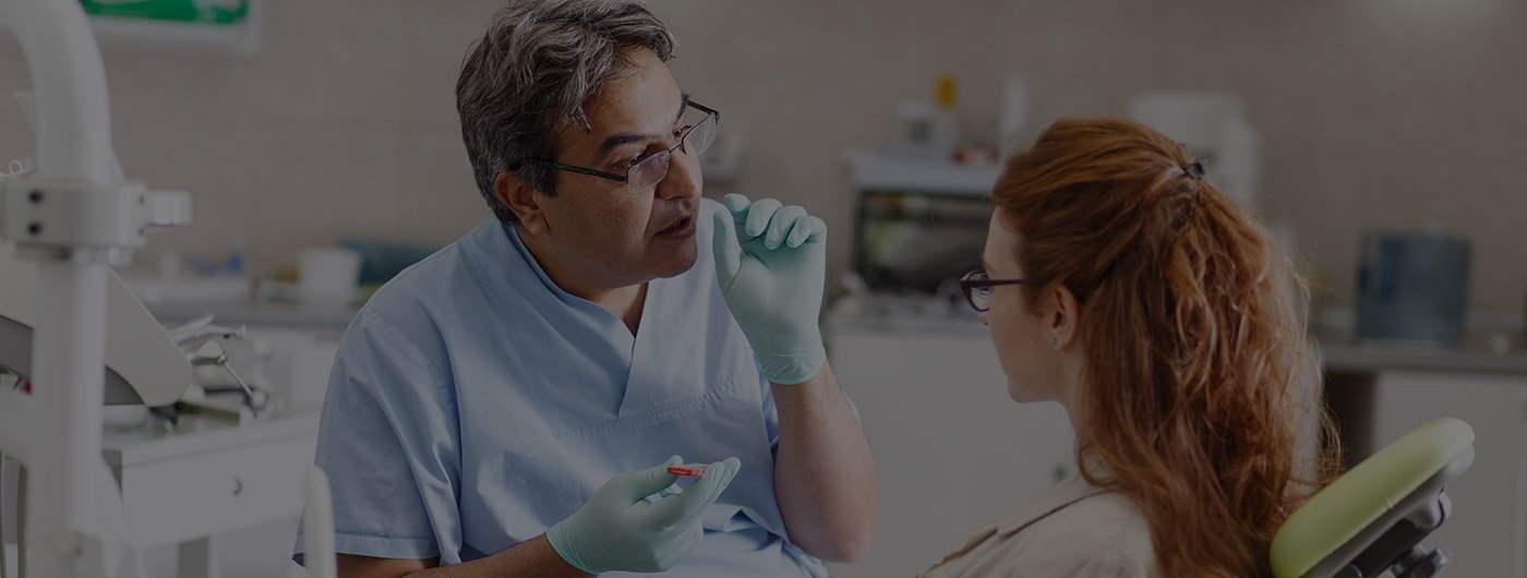 Dentist talking to patient in dental chair