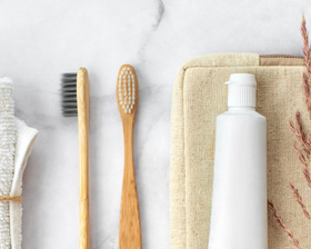 toothbrushes and toothpaste laying on a marble countertop  