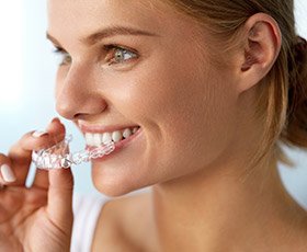 Woman placing Invisalign tray