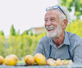a man with dentures smiling after eating a meal 