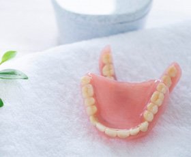 a pair of dentures resting atop a soft towel 