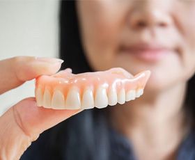 a person in Washington holding their dentures