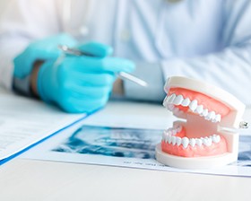 A close up of dentures near a working dentist
