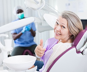 Woman giving thumbs up after dental implant surgery in Washington, DC