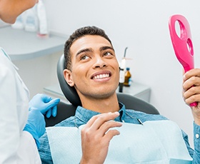 Young man smiles after getting dental implants in Washington