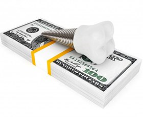 Dental implant atop stack of money symbolizing cost of dental implants in Washington