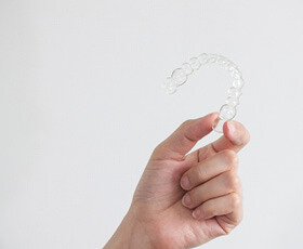 patient holding invisalign clear aligner