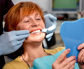 Senior woman looking at smile in mirror