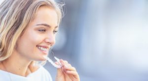 attractive young woman inserting Invisalign in downtown