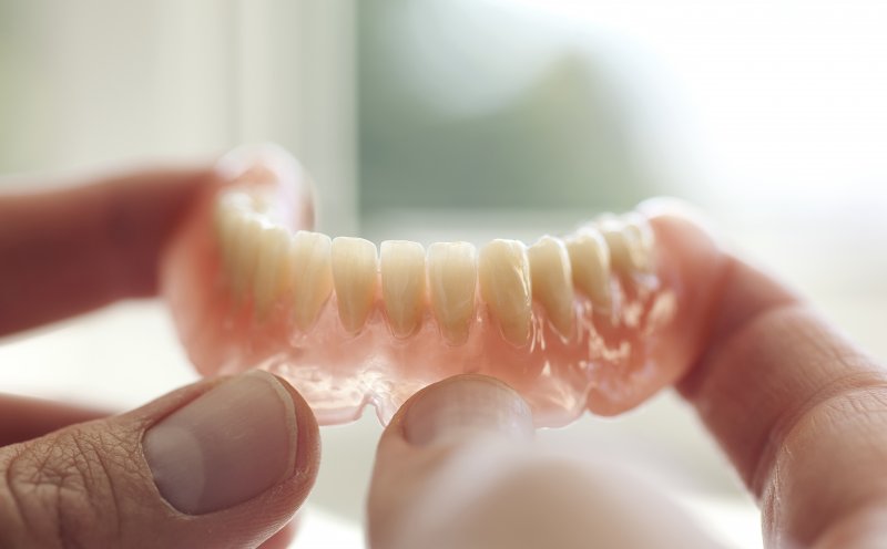 person holding dentures