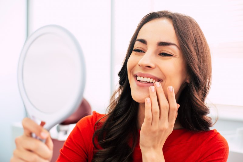 A woman giving thanks for her dental implants