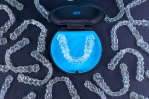 Clear aligners and storage case on black background