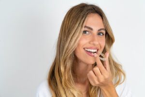 Woman with pretty smile about to put in Invisalign.