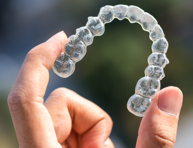 Close up of hand holding clear aligner